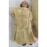 Small 1930's painted composition doll wearing a cream dress