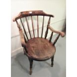 Early 20th Century beechwood spindle back elbow chair, the circular panel seat on turned supports