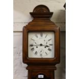 Modern German Vienna type wall clock with a calendar dial and shaped pendulum window, 46ins high