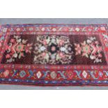 Anatolian rug with stylised floral design on a dark centre panel with polychrome borders, 7ft x