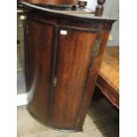 George III oak and mahogany crossbanded two door bow front hanging corner cabinet