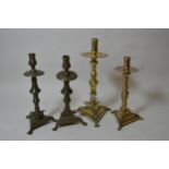 Two 19th Century Continental brass baluster form candlesticks with triangular bases, the tallest