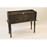 Rectangular carved oak jardiniere decorated with floral carvings and raised on turned tapering