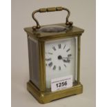 Small brass cased single train carriage clock with enamel dial and Roman numerals, together with