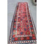 Kazak runner with an all-over Boteh design on a red ground with star pattern border, 12ft x 3ft 2ins