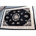 Chinese carpet with medallion and dragon design on a black ground with borders, 11ft x 7ft