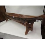 Native Carved hardwood model canoe on a hardwood stand, 43ins long