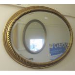 20th Century oval gilt framed wall mirror with bevelled plate, 26.5ins x 36ins, together with