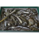 Small box containing a collection of various silver and plated flatware, including sugar tongs,