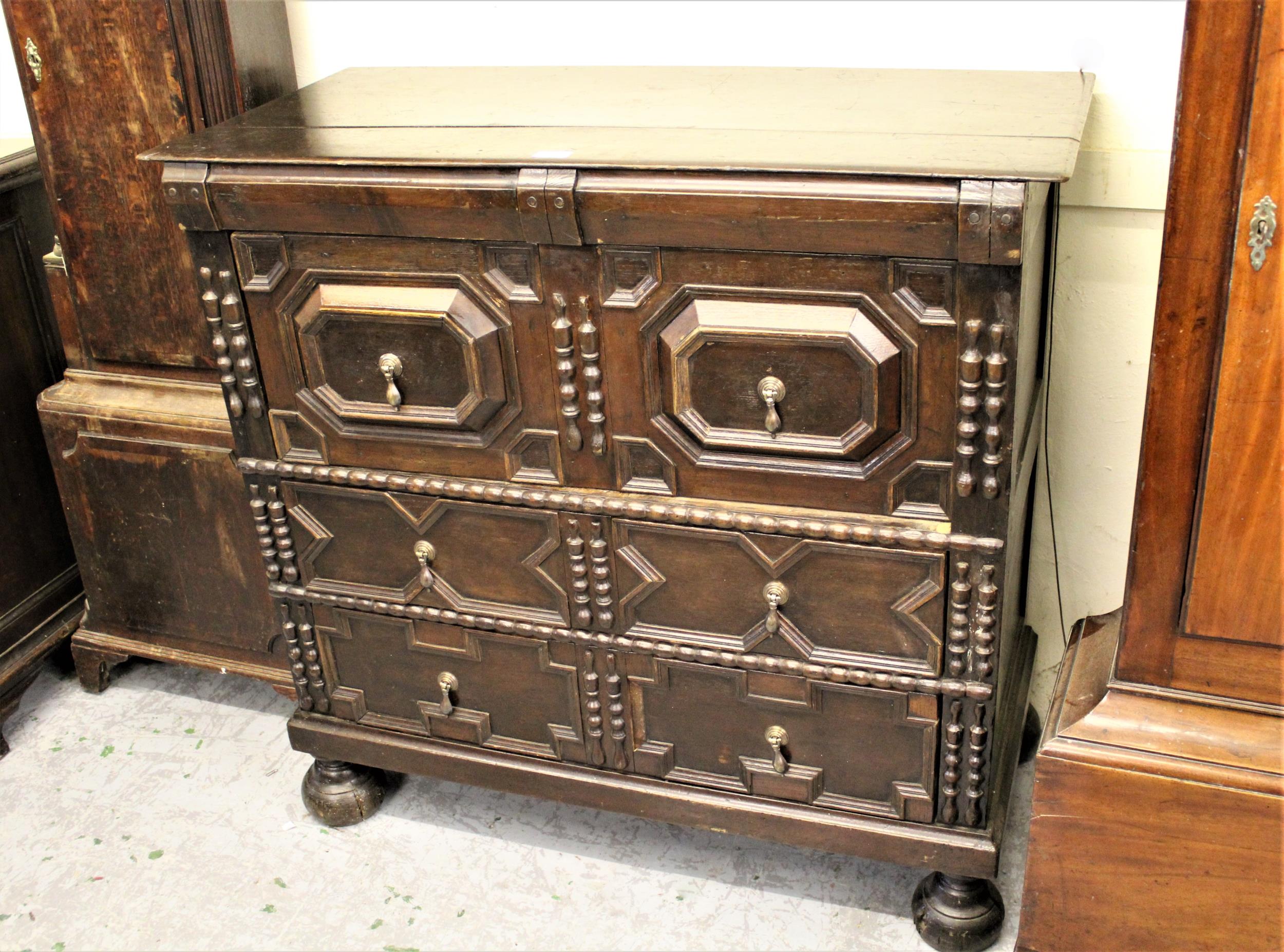 Early 18th Century style oak chest, the plank top above three moulded drawers, raised on low bun