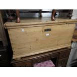 Early 20th Century rectangular pine blanket box with hinged cover raised on bun supports, 20ins high