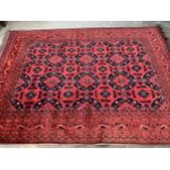 Small Afghan carpet with an all-over stylised flowerhead and panel design in shades of deep red