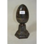 Brown patinated bronze egg form sculpture mounted on hexagonal stepped base, 10ins high