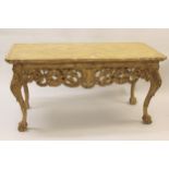 Carved and painted centre table in 18th Century Irish style, the shaped grained top above a carved