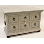 Low side cabinet of six small short drawers with painted finish and panelled sides This is a