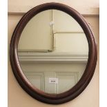 Oval walnut framed wall mirror together with a rectangular wavy edge walnut wall mirror