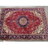 Tabriz carpet with a lobed medallion and all-over floral design on a red ground with corner