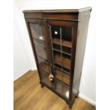 Mid 20th Century oak bookcase, having two leaded glazed doors on cabriole pad supports 24ins wide