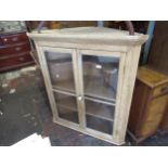 Pine corner cabinet with a moulded cornice above a pair of bar glazed doors enclosing shelves, 39ins