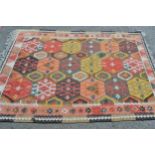 Kelim rug with an all-over hooked medallion and panel design in shades of pink, yellow, salmon,
