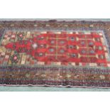 Belouch prayer rug, the deep red central field within a multiple border of beige, blue, red and