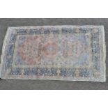 Cotton rug of Persian design with a lobed medallion and all-over floral pattern in shades of pale