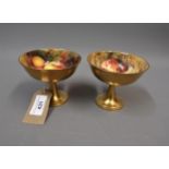 Pair of Royal Worcester pedestal cups internally painted with fruits, one by Ricketts, the other