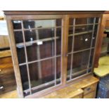 Mahogany wall cabinet with two glazed doors enclosing shelves above a shaped apron, 30.75ins wide