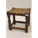 Robert (Mouseman) Thompson, oak stool with woven leather seat on typical octagonal baluster supports