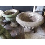 Near pair of weathered cast concrete pedestal garden urns of circular fluted design, 16ins x 19ins