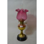 Late 19th / early 20th Century brass and copper oil lamp, having cranberry glass shade