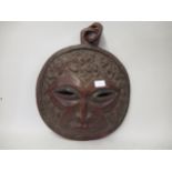 Circular native hardwood wall mask carved with dancing figures, approximately 15ins diameter