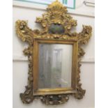 20th Century Continental carved and gilded cartouche mirror, the shaped surmount with a central