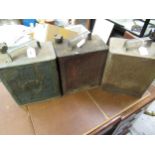 Three vintage petrol cans and various brass caps