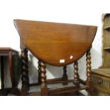 Mid 20th Century oak oval drop leaf side table on barley twist supports together with a