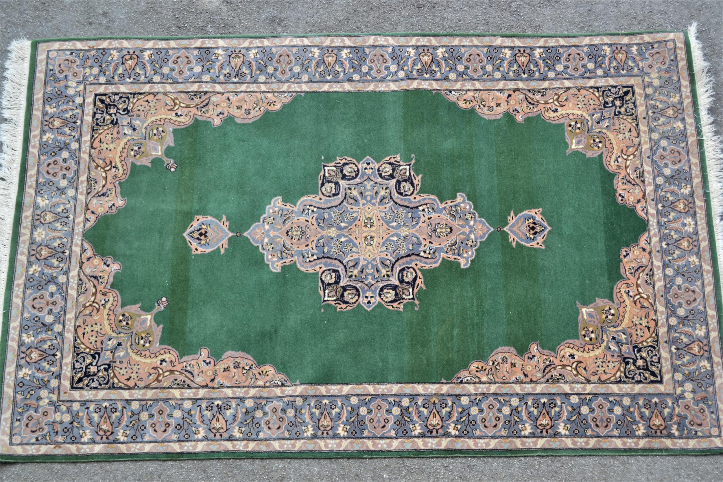 Indo Persian rug with central medallion and multiple borders on green ground, 88ins x 54ins Some