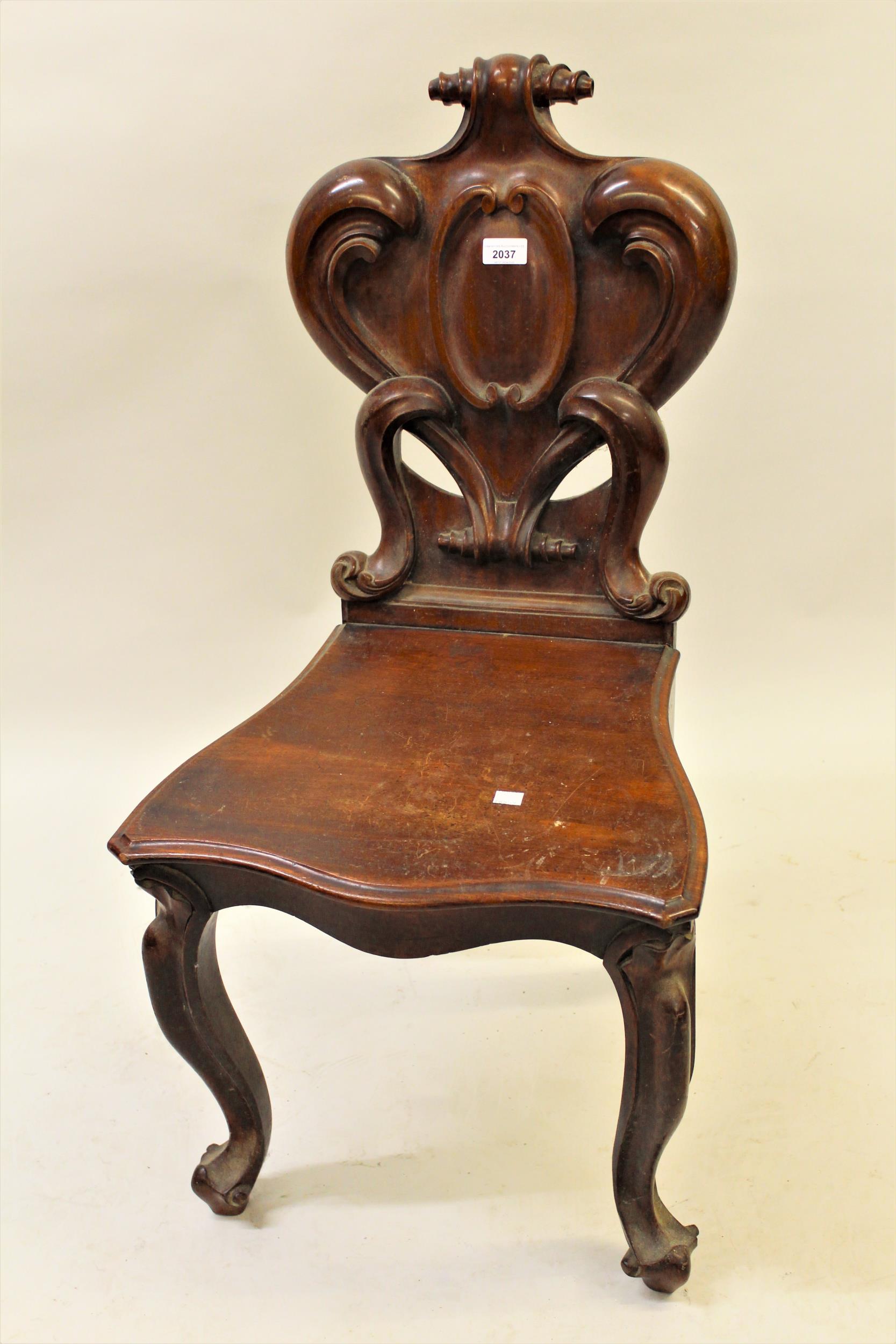 Victorian carved mahogany hall chair with a shaped back and panel seat on cabriole front supports