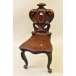 Victorian carved mahogany hall chair with a shaped back and panel seat on cabriole front supports