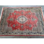 Large Indo Persian carpet with a medallion and vase design on a salmon ground with corner designs