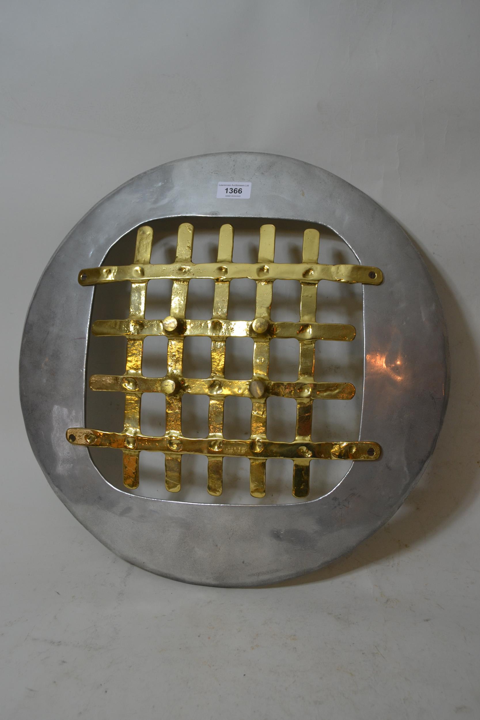 David Marshall, polished aluminium and brass wall plaque of circular pierced shield design, 19.75ins