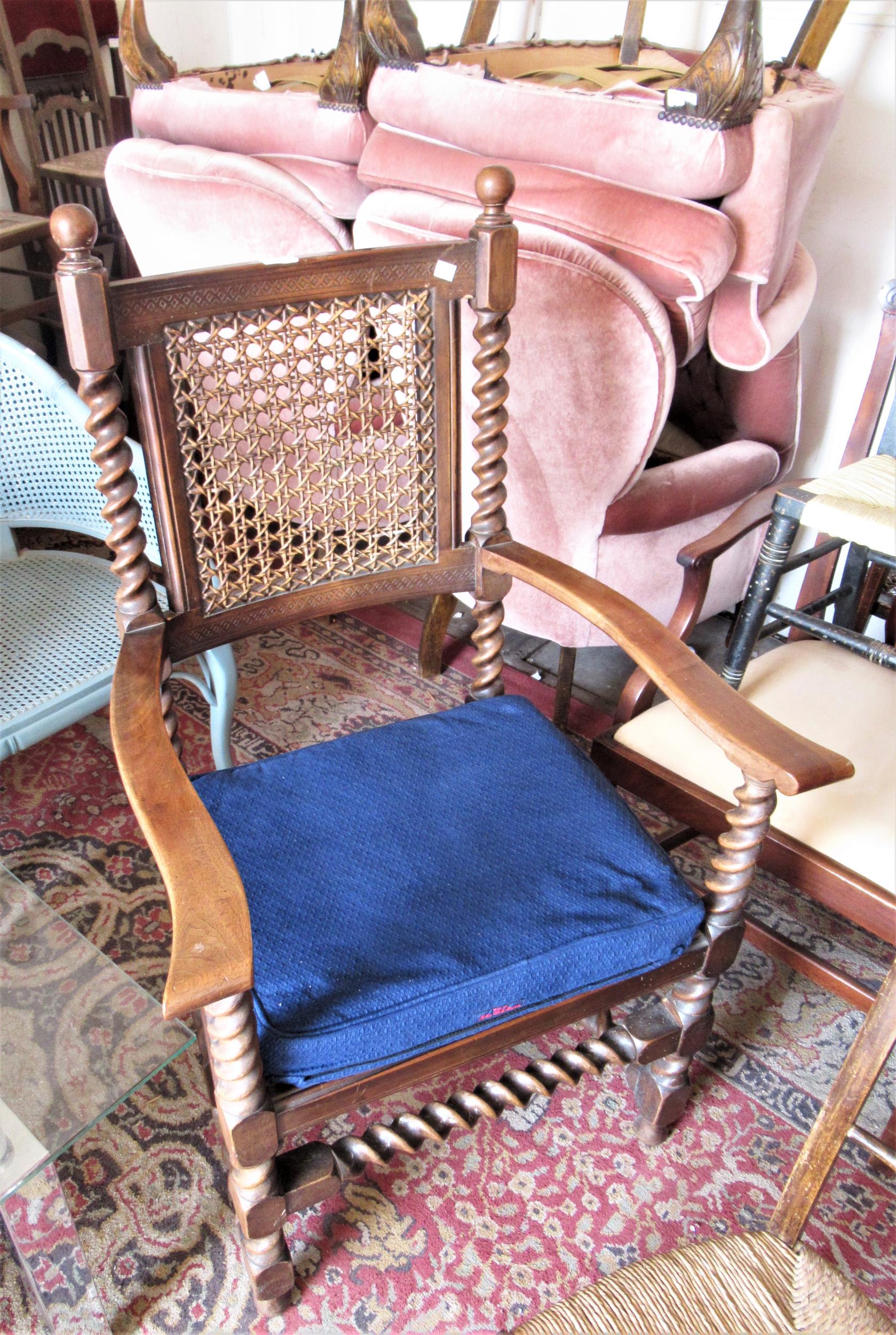 Early 20th Century walnut open armchair in Carolean style with a cane back and seat on barley