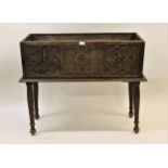 Rectangular carved oak jardiniere decorated with floral carvings and raised on turned tapering