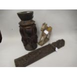 African carved hardwood candle holder decorated with faces, carved figure of a bearded saint and a