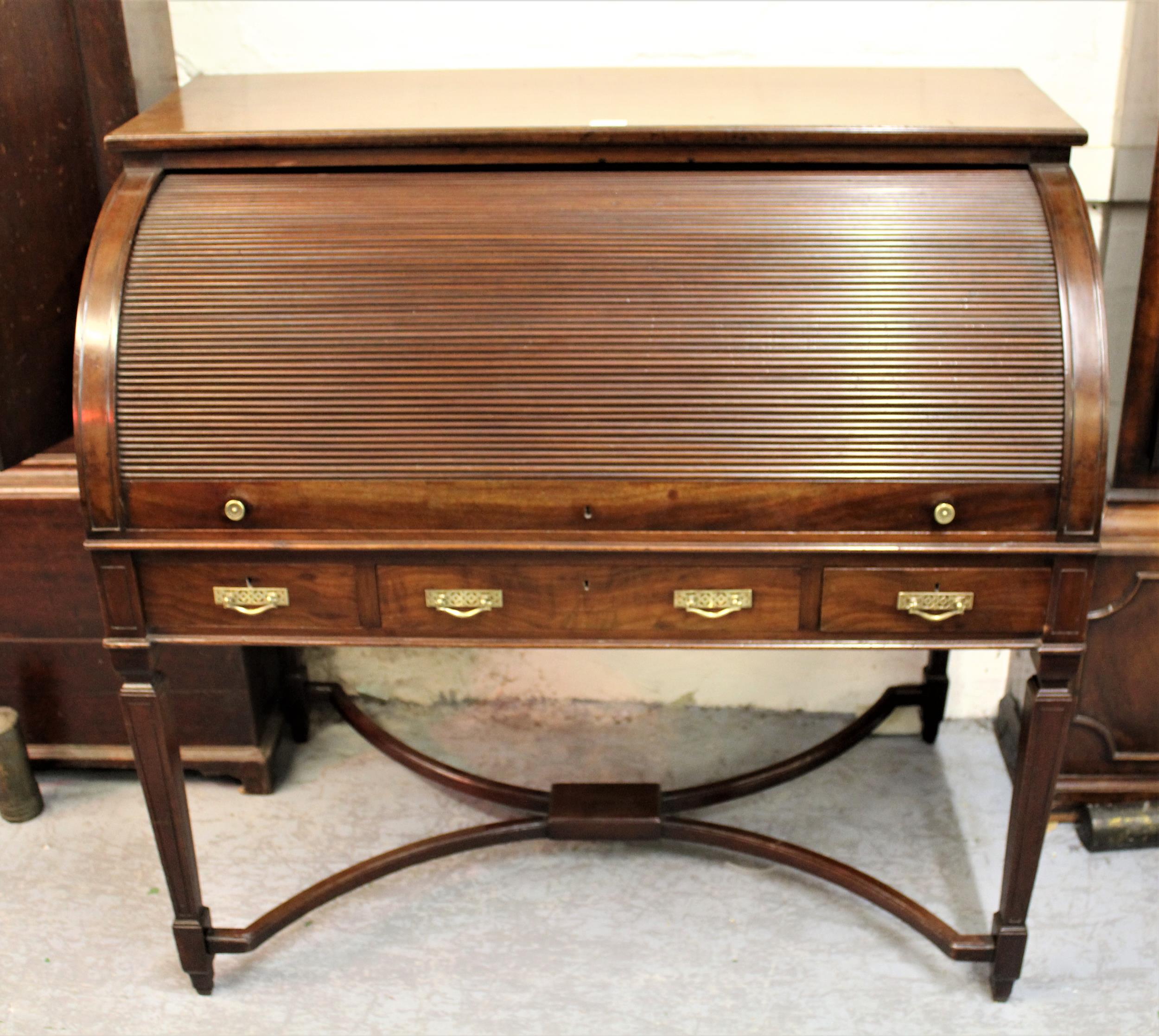 19th Century mahogany tambour desk opening to reveal a fitted interior with pull-out writing surface