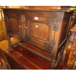 20th Century oak side cabinet having two panelled doors with knob handles, raised on turned supports