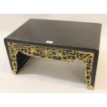 20th Century low Chinese opium table having black over red lacquer finish with gilded decoration (at