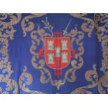 Applique wall hanging decorated with a central coat of arms on a blue ground, 5ft 6ins x 6ft