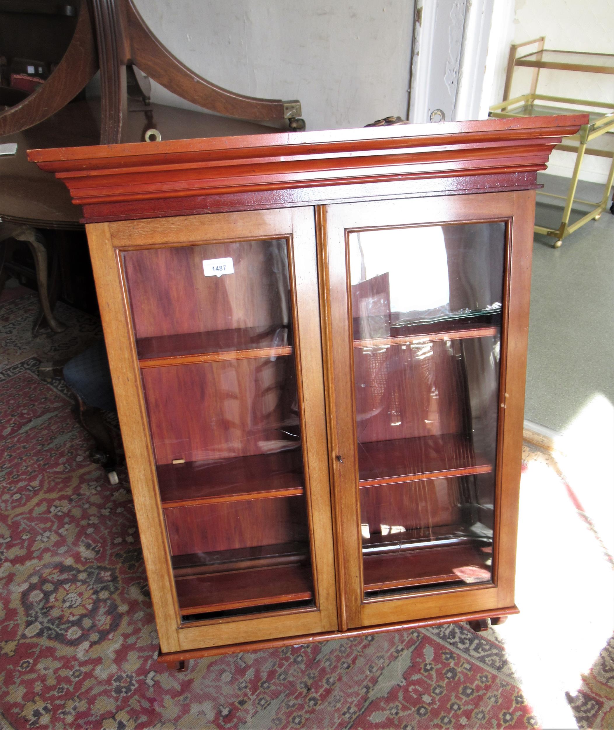 Mahogany and pine wall cabinet with two glazed doors enclosing shelves above a shaped apron, 27.5ins