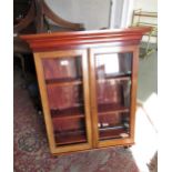 Mahogany and pine wall cabinet with two glazed doors enclosing shelves above a shaped apron, 27.5ins