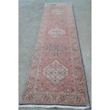 Indo Persian runner with a repeating medallion and all-over Herati design on a rose ground with